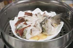 將鱸魚成花狀擺好，將火腿切片放入各縫隙中，放入鍋中隔水蒸12分鐘拿出，撒上蔥花即可。
