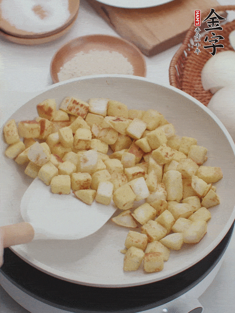 起鍋熱油，倒入饅頭丁，小火煎至蛋液凝固定型再翻面，饅頭丁部煎至金黃時盛起待用。