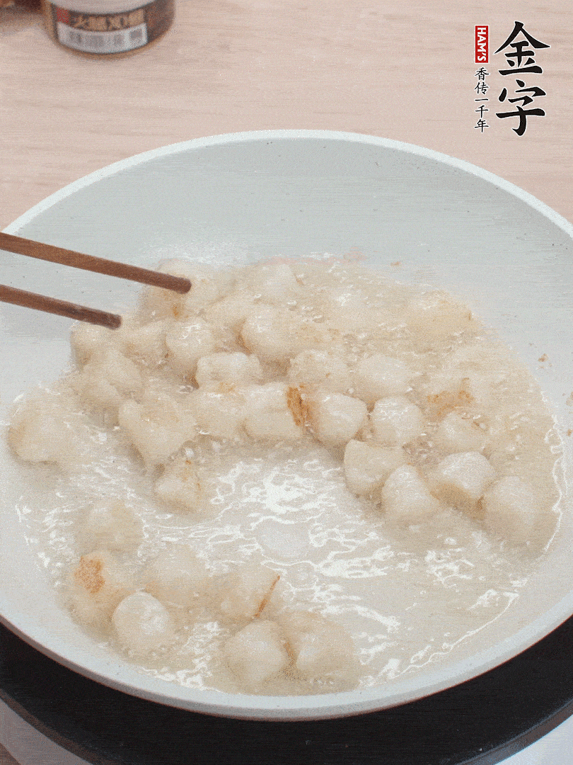 油溫4成熱，鮮貝蘸干淀粉下鍋煎，一面微黃后翻面。