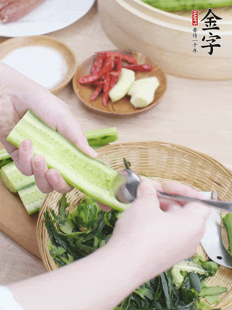 黃瓜削皮，對(duì)半切開(kāi)，勺子挖去內(nèi)瓤，斜刀切片。青蒜斜刀切段。