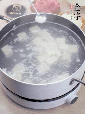豆腐切成大小均勻正方體，鍋內(nèi)放水，加一點鹽焯水10秒。